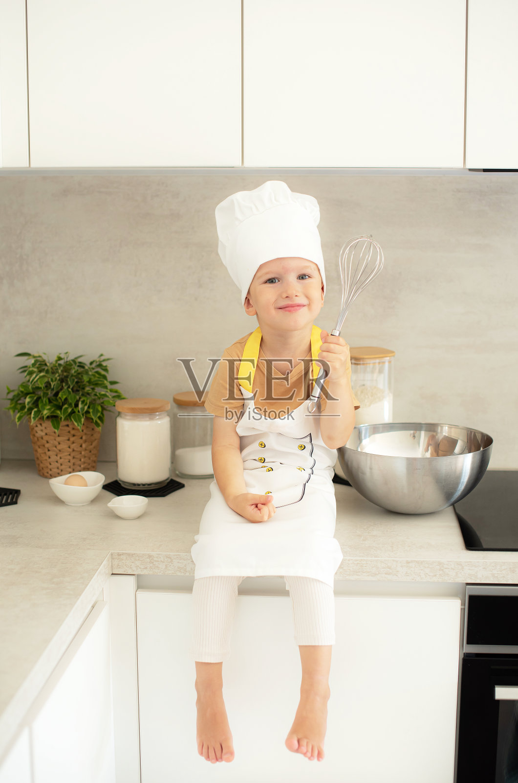 小白种男孩对厨师帽烹饪在厨房家庭早期教育发展围裙配料照片摄影图片