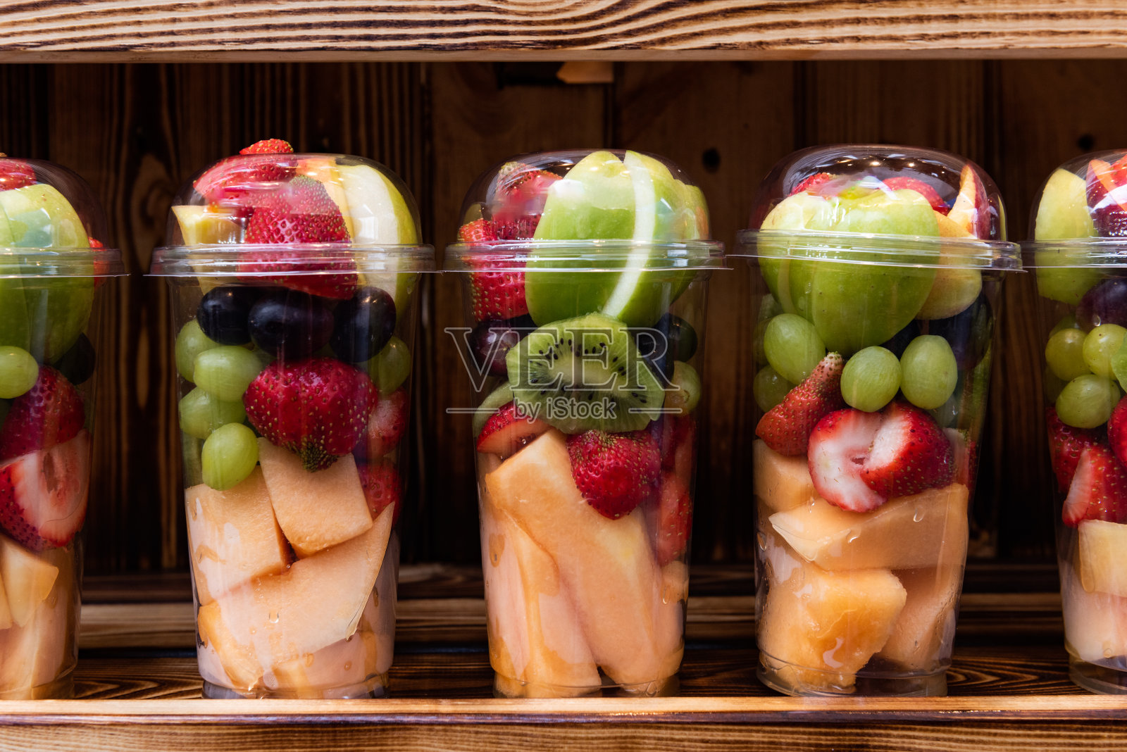 塑料杯中的鲜切什锦水果照片摄影图片