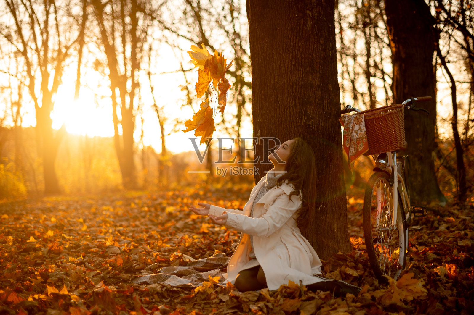 骑自行车的美丽的长头发的女人坐在她的自行车附近的肖像照片摄影图片