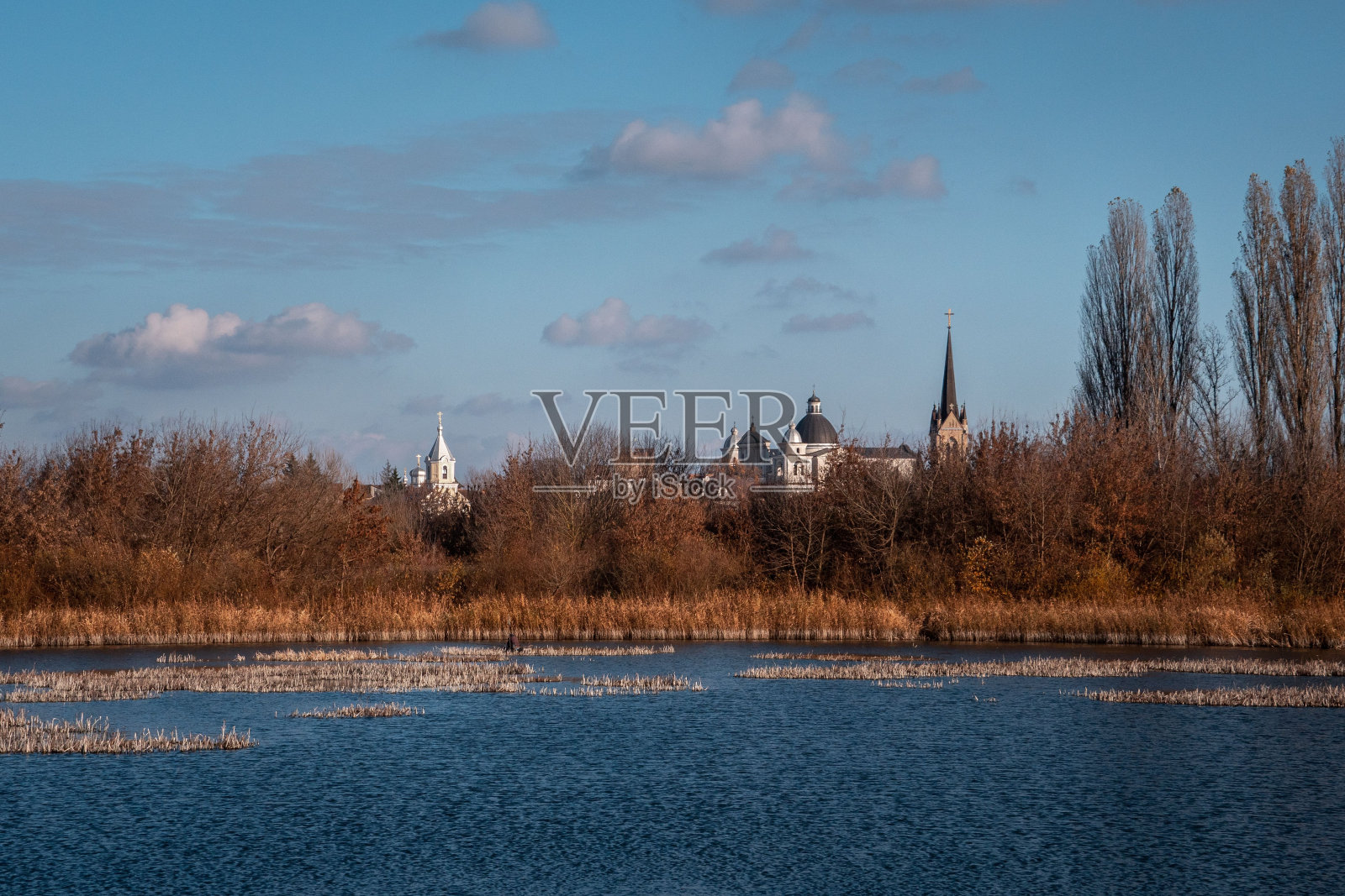 宁静的水域，背景是古老的教堂。乌克兰卢茨克的秋天照片摄影图片