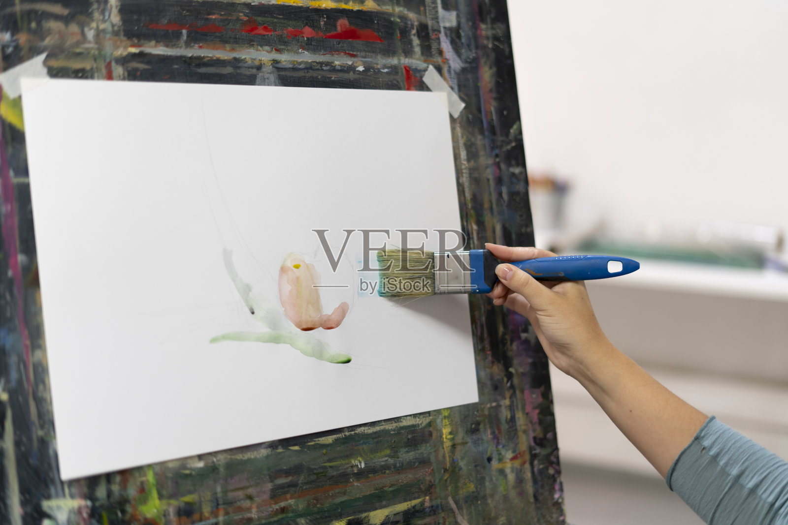 近距离的大笔画在白纸上，艺术家的手拿着画笔照片摄影图片