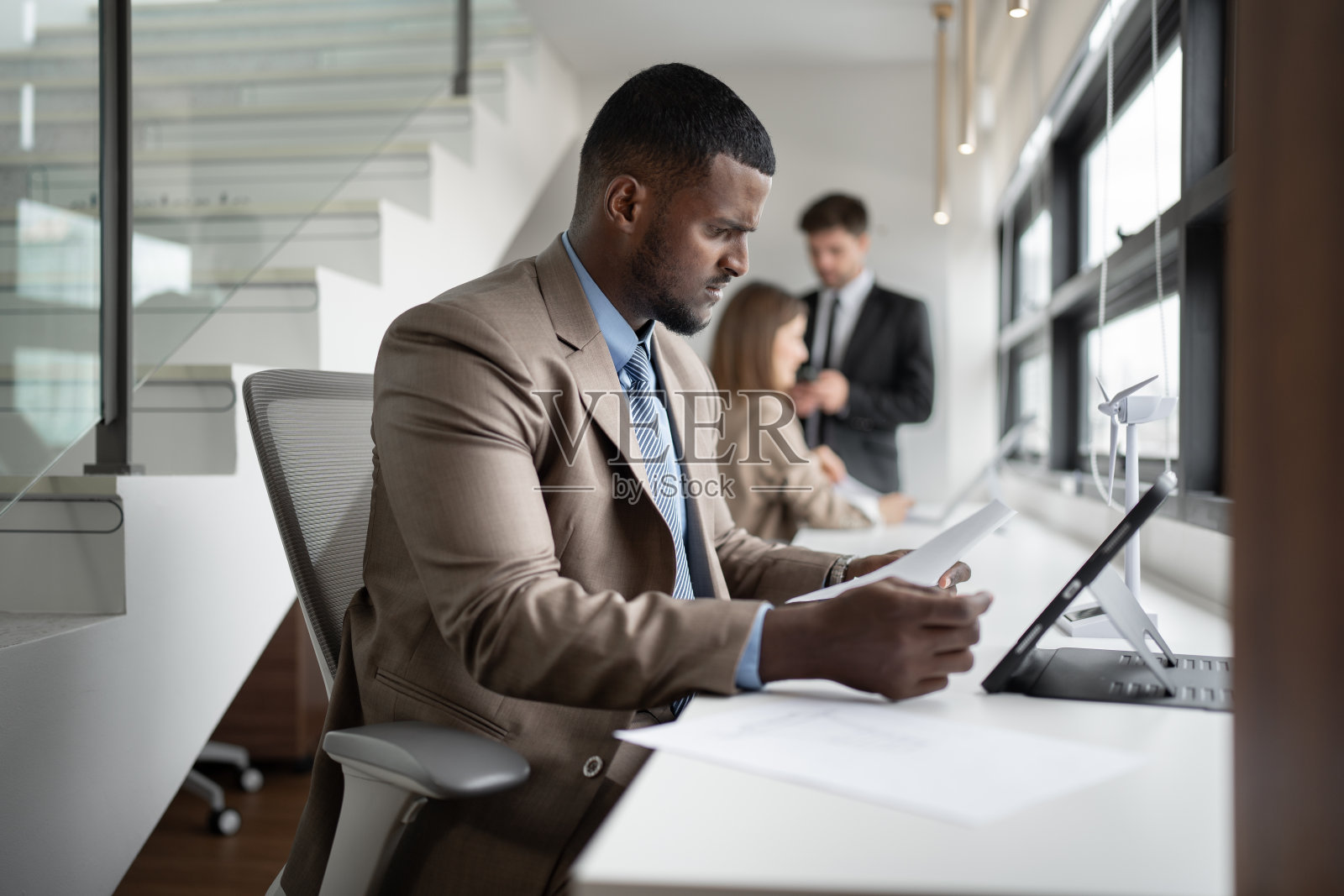 非洲商人在办公室用平板电脑和文书工作照片摄影图片