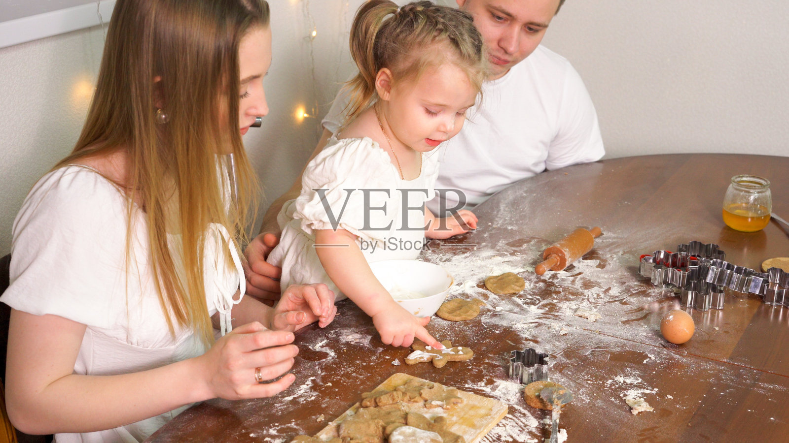 一家三口一起自制形状的饼干。舒适舒适的家庭氛围照片摄影图片