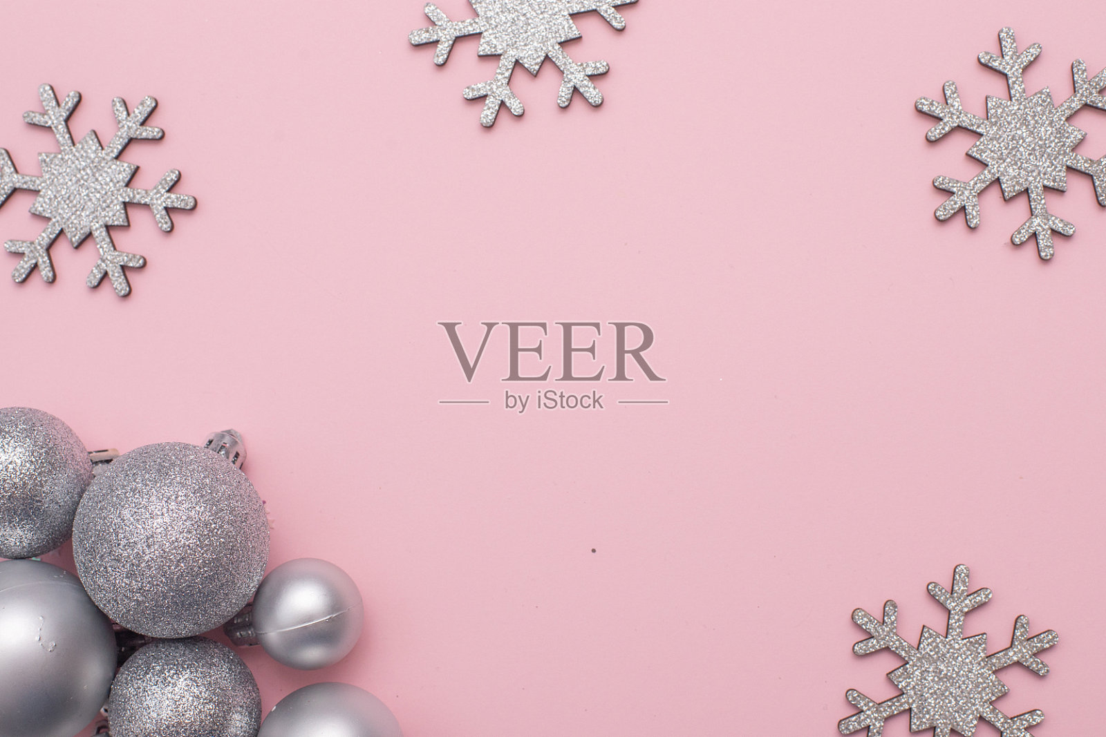 圣诞构图平铺圣诞银树玩具，银白色雪花在粉红色的背景下。照片摄影图片
