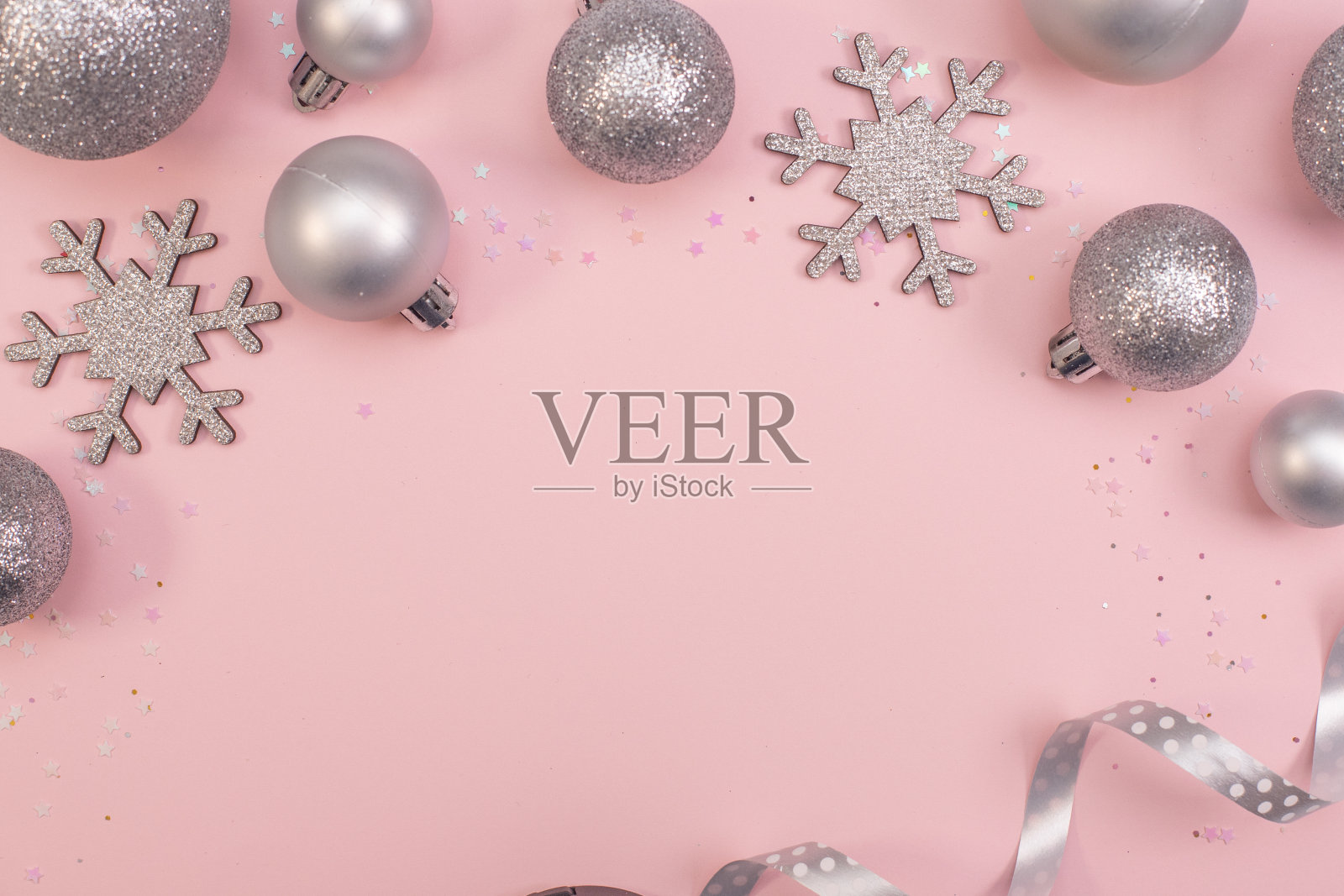 圣诞构图平铺银色和粉红色的圣诞树玩具，银色的雪花在粉红色的背景下。照片摄影图片