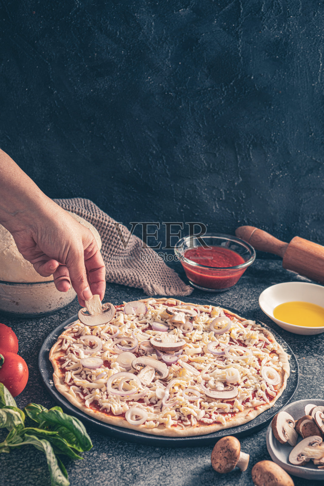 混凝土桌子上的披萨配火腿和蘑菇照片摄影图片