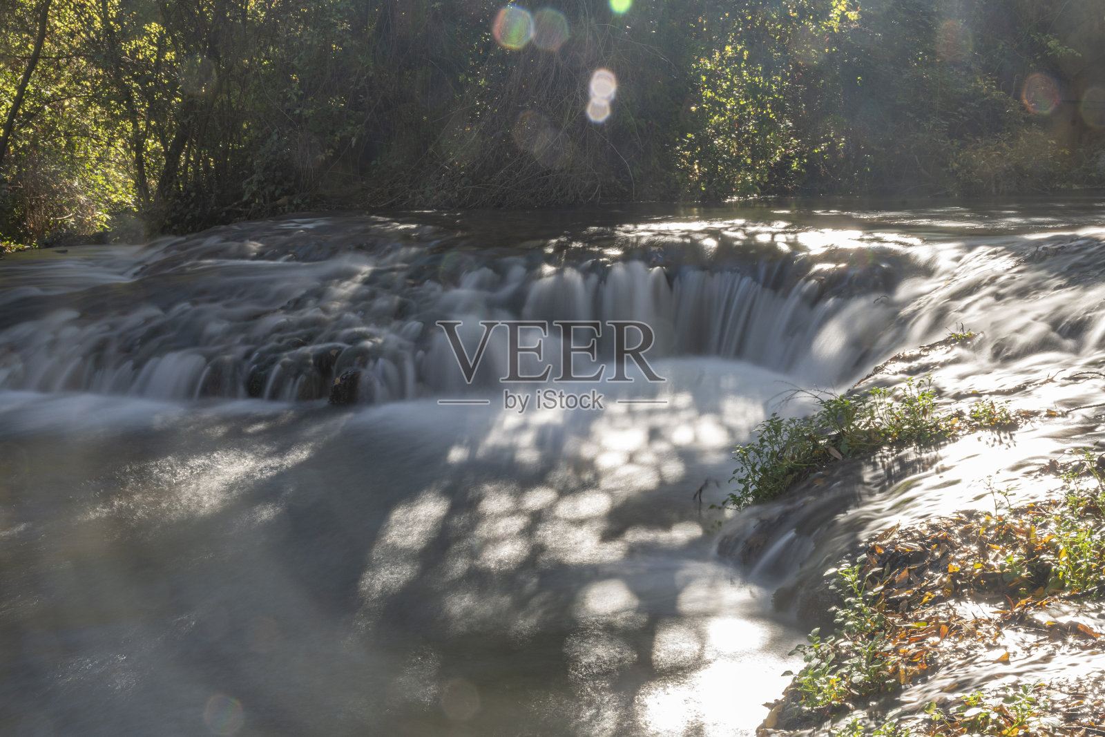西班牙萨拉戈萨，石头修道院中的瀑布。瀑布与丝绸水的效果。柔滑的水。石头寺院里的瀑布。被树木和植被环绕的瀑布。西班牙自然公园照片摄影图片