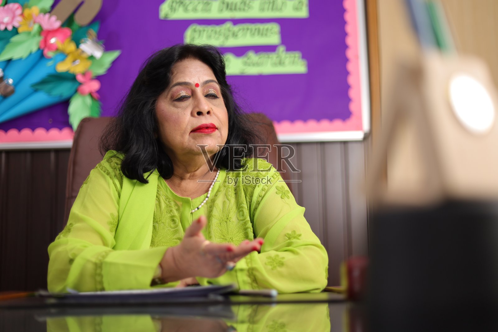 校长高兴地坐着，为她学校的学生们感到骄傲，面带微笑照片摄影图片