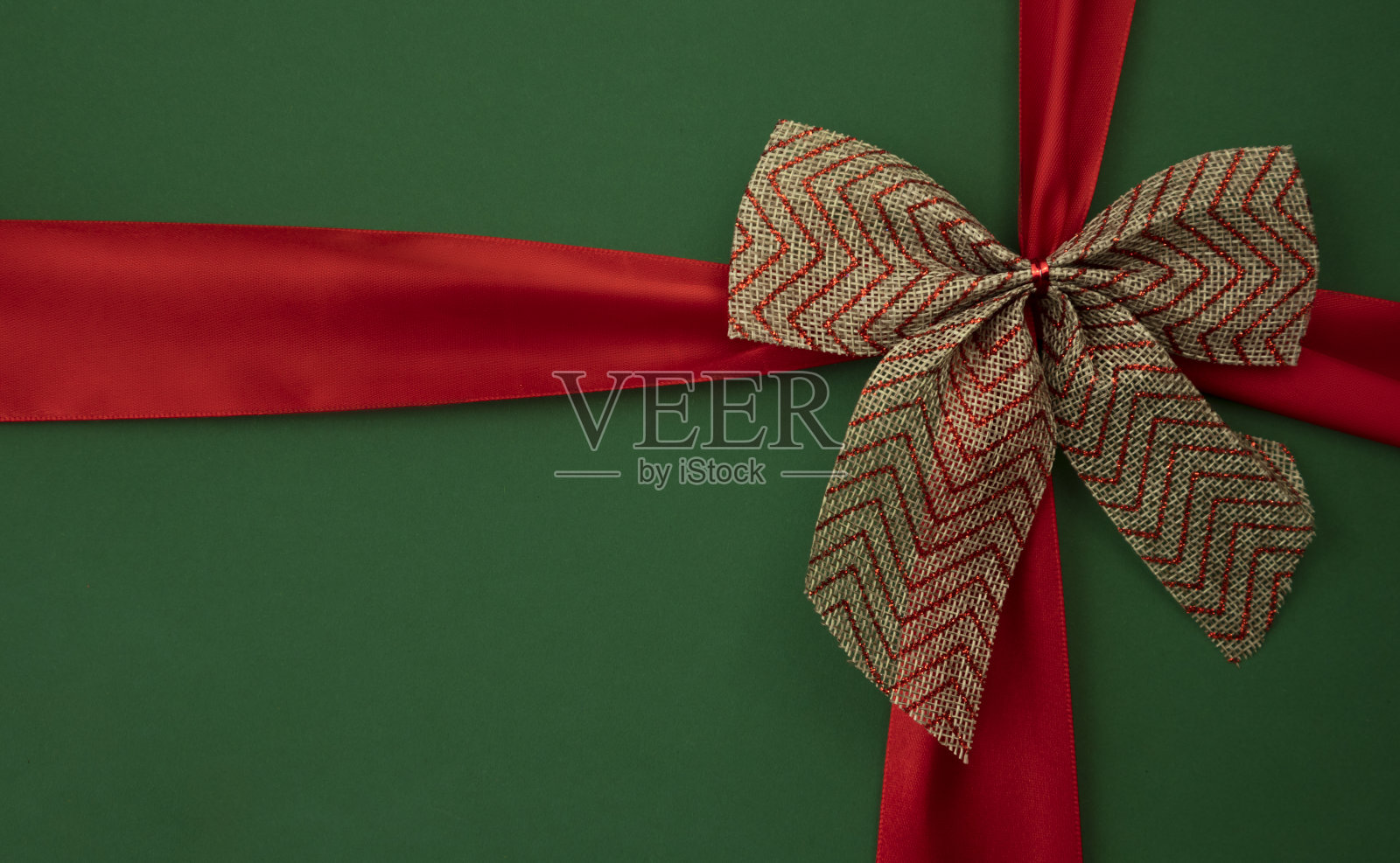 绿色背景上的蝴蝶结和红丝带照片摄影图片