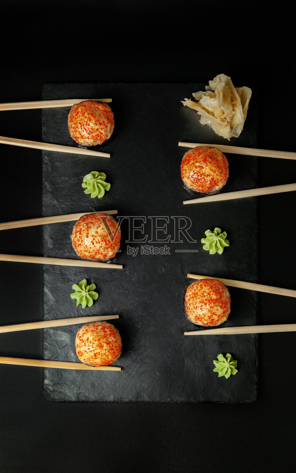 热腾腾的寿司，桌上放着棍子。俯视图照片摄影图片
