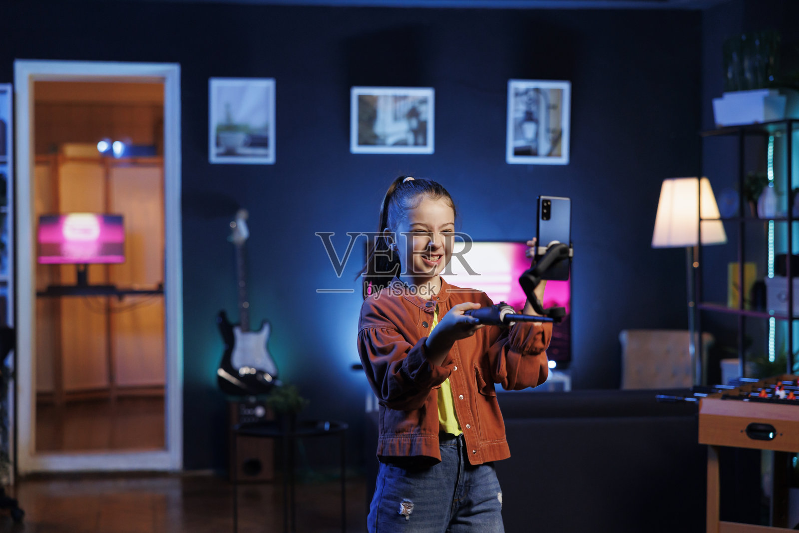 年轻的网络明星在客厅里载歌载舞，为社交媒体拍摄视频照片摄影图片