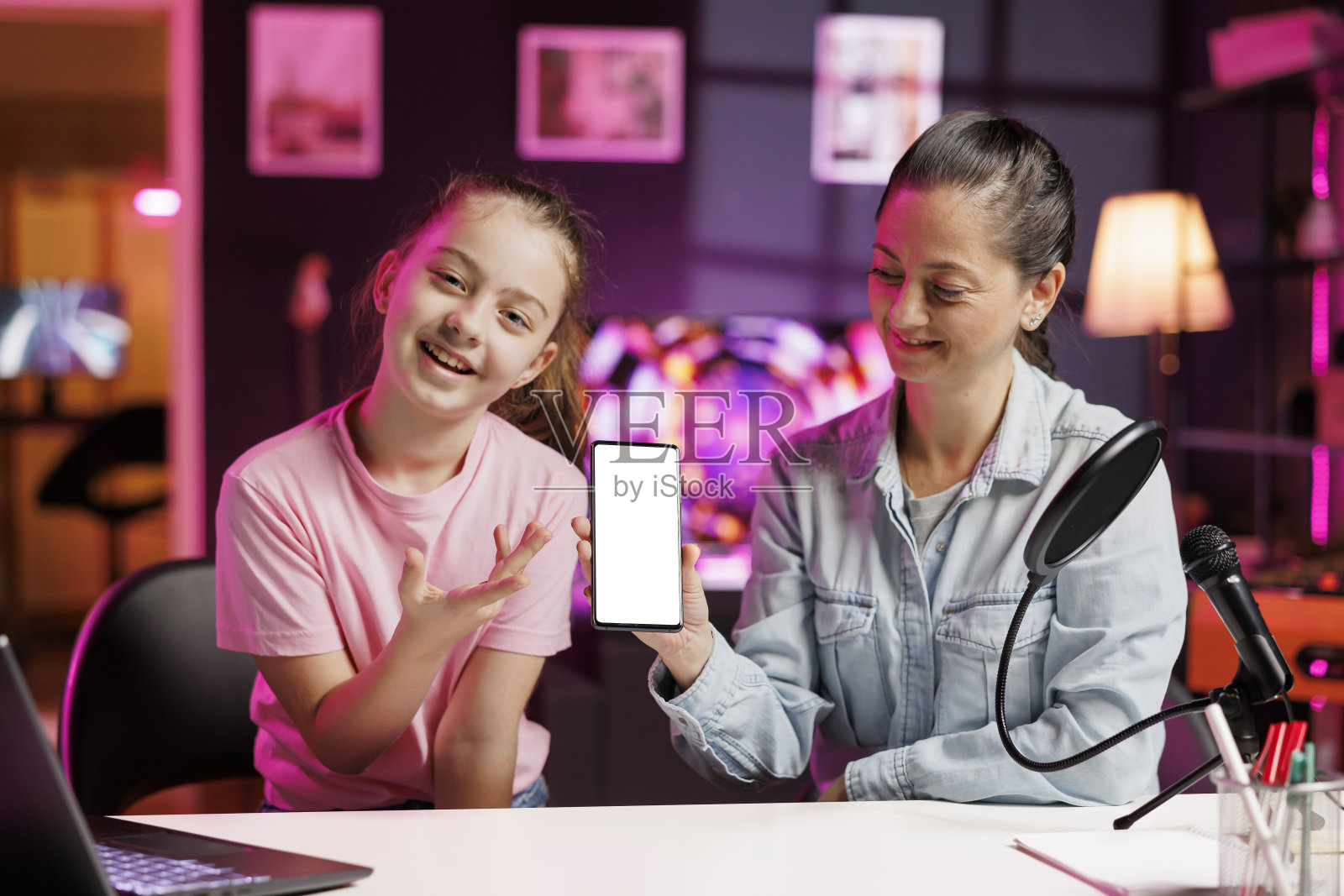 儿童网络节目主持人和妈妈拍摄关于市场上最好的手机模型的内容照片摄影图片