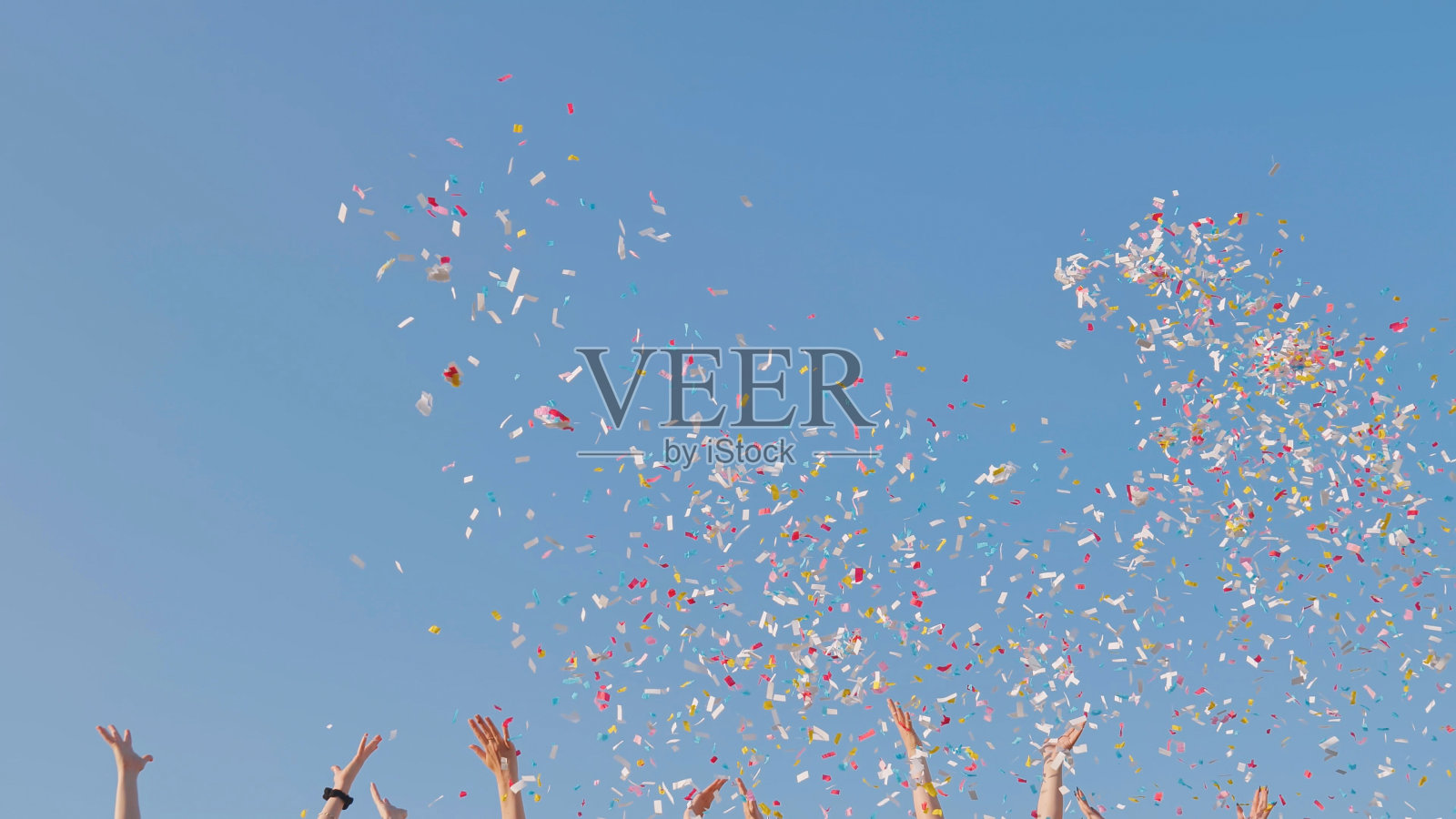 从年轻人手中扔五彩纸屑。照片摄影图片