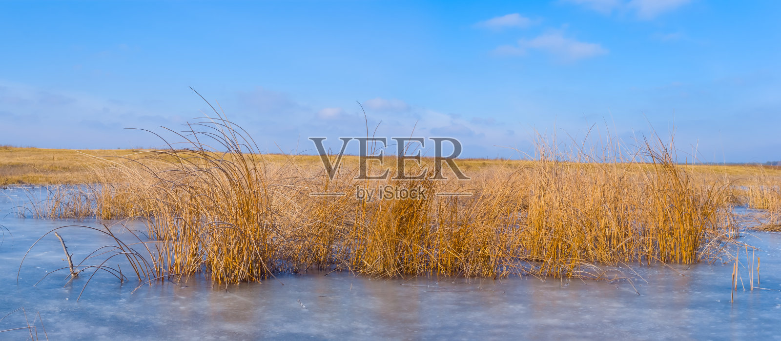 蓝色多云的天空下结冰的冬天河流照片摄影图片