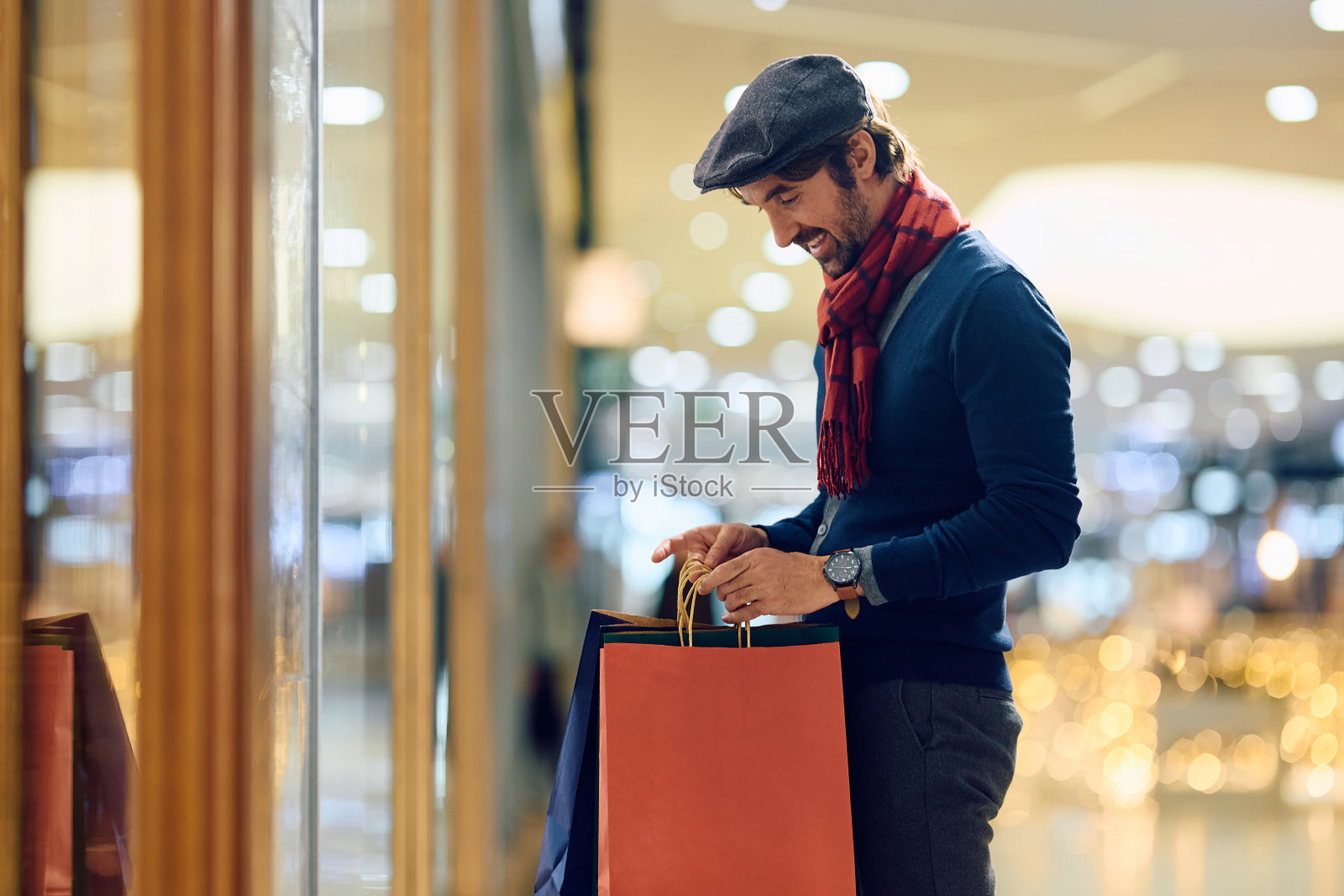 一个快乐的人在购物中心享受购物。照片摄影图片