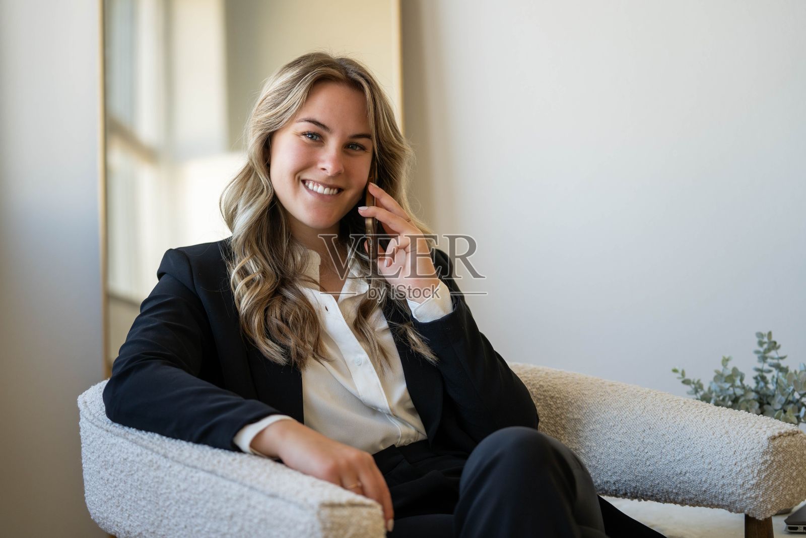 一个三十多岁的成熟女人一边打电话一边微笑照片摄影图片