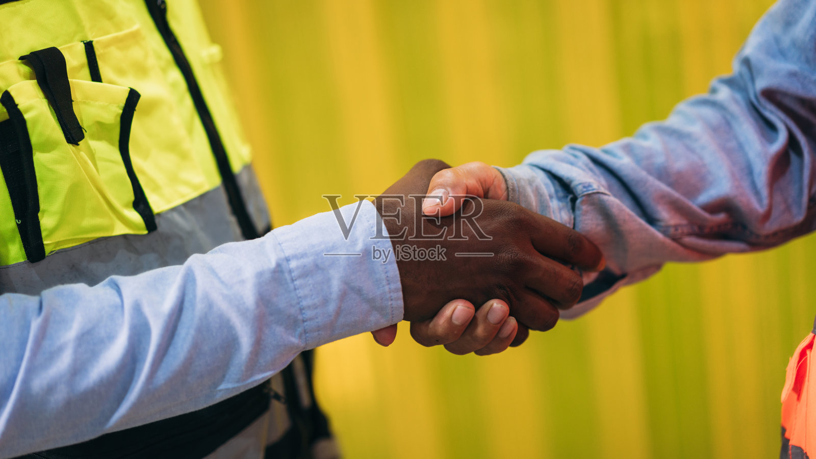 团队工程师和领班手拉手握手，以显示在工厂机器上的成功。工业携手合作。照片摄影图片