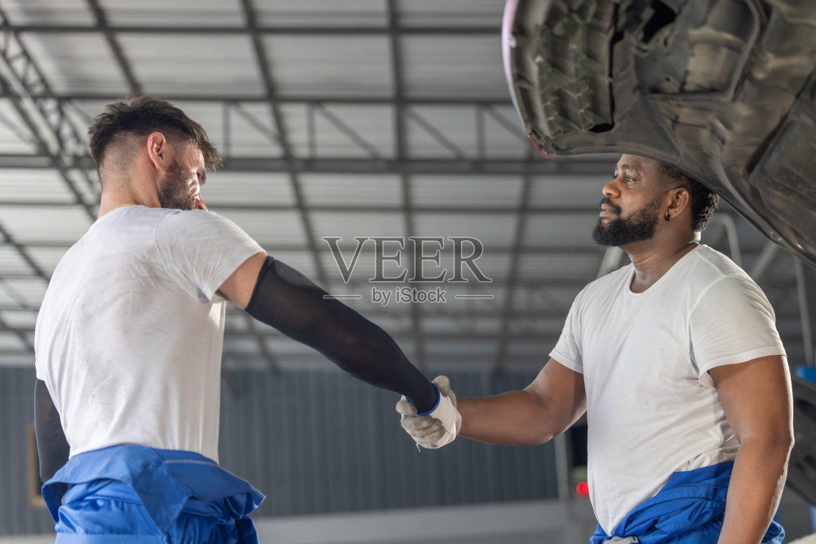 汽车修理工精心打造团队建设仪式，在积极的车库氛围中培养成功的联系。照片摄影图片