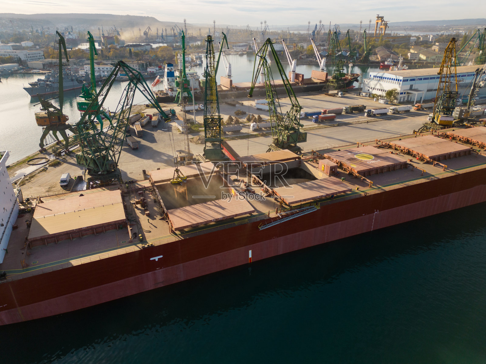 日落时分，一艘装载着小麦的大型散货船在港口鸟瞰图照片摄影图片