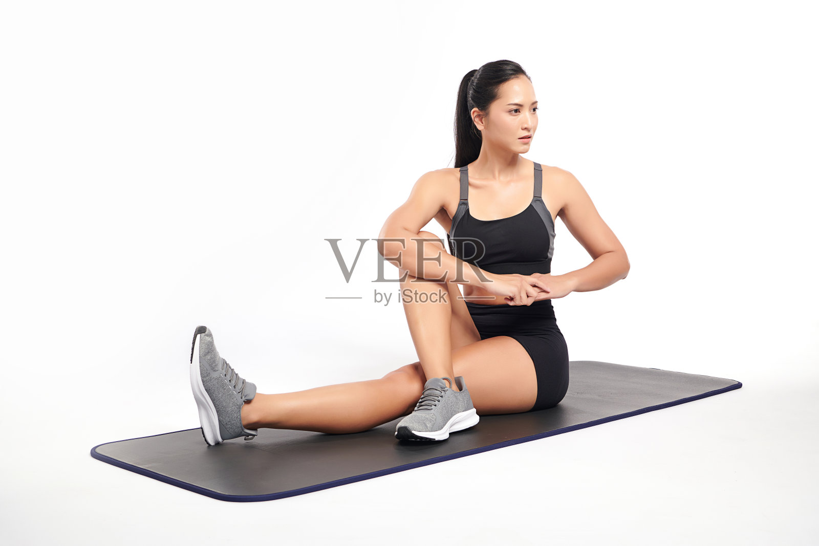 一位亚洲妇女穿着白色背景的运动服正在健身。照片摄影图片