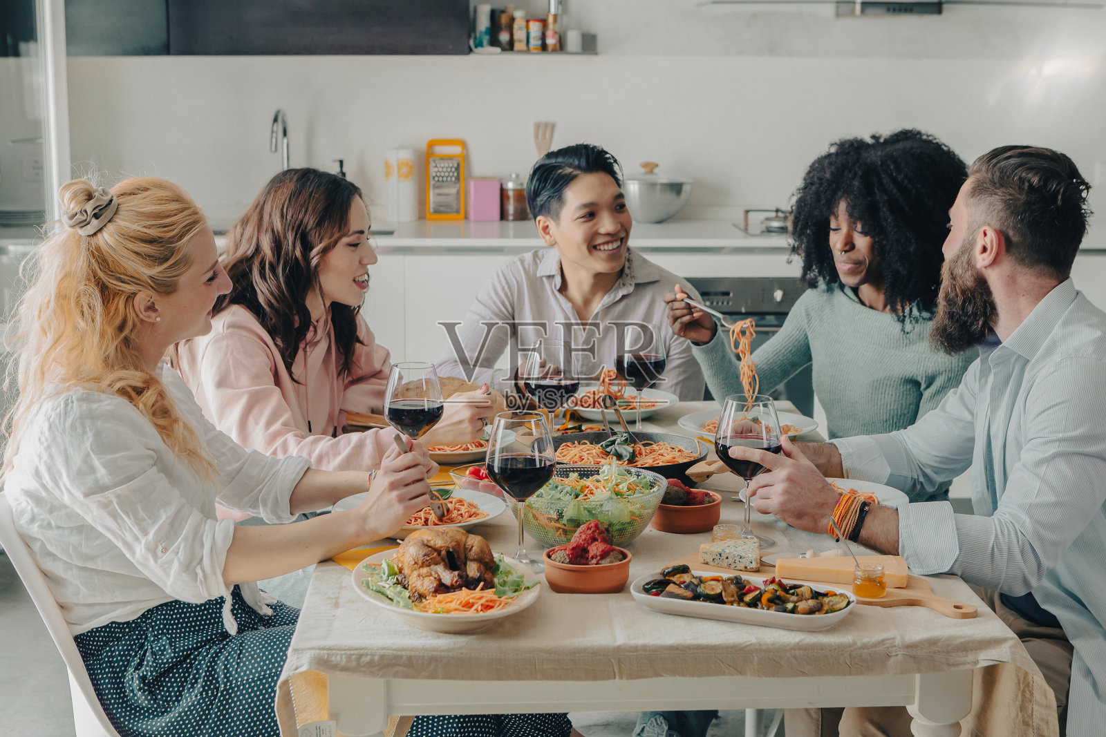 一群不同种族的朋友在午餐时坐在餐桌旁照片摄影图片