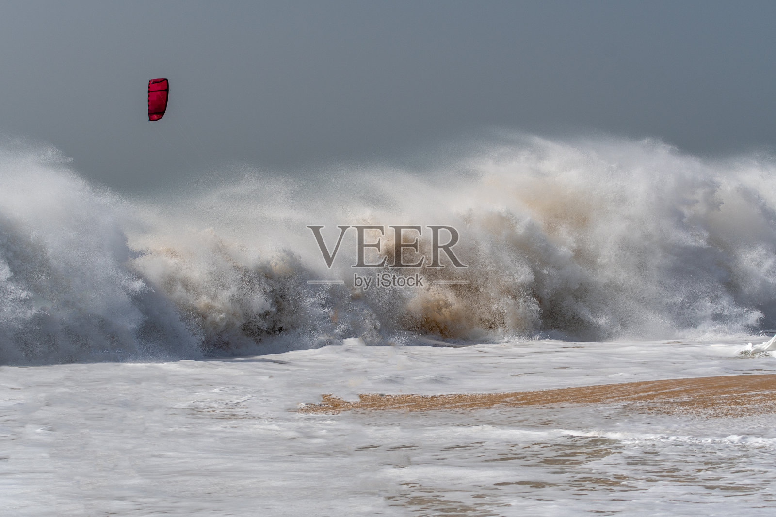 风筝冲浪者在波涛汹涌的大海中冲浪照片摄影图片