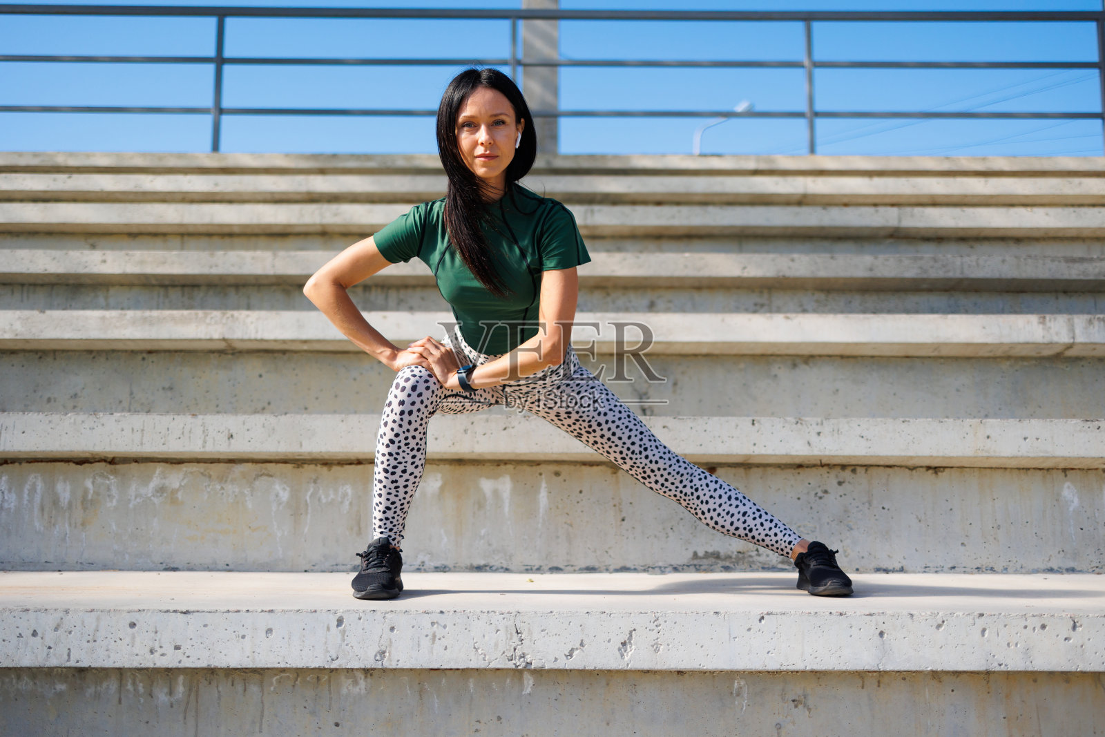 活跃的年轻女子的腿伸展在体育场照片摄影图片