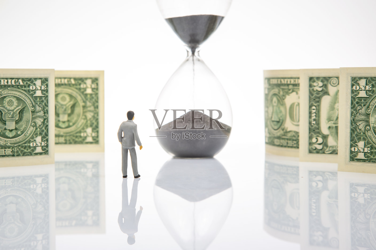 微型的人。商人站在美元附近，沙漏。经营理念照片摄影图片