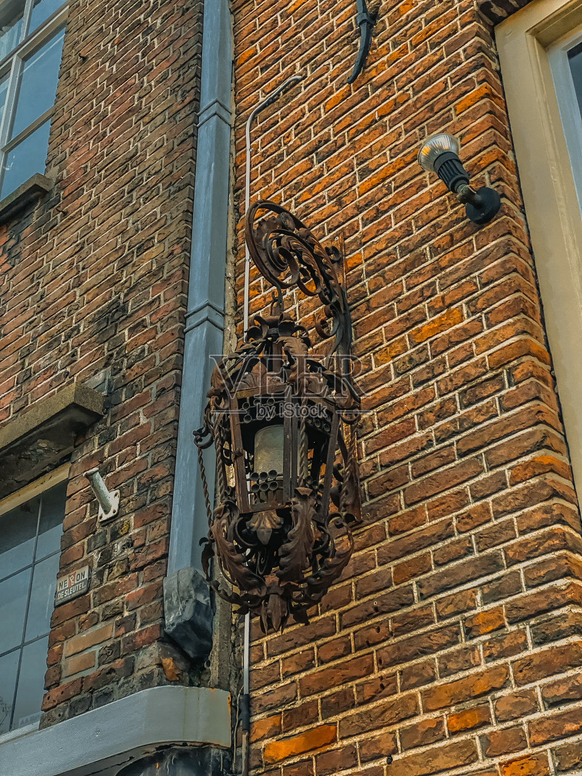 荷兰阿姆斯特丹一所老房子墙上的路灯照片摄影图片