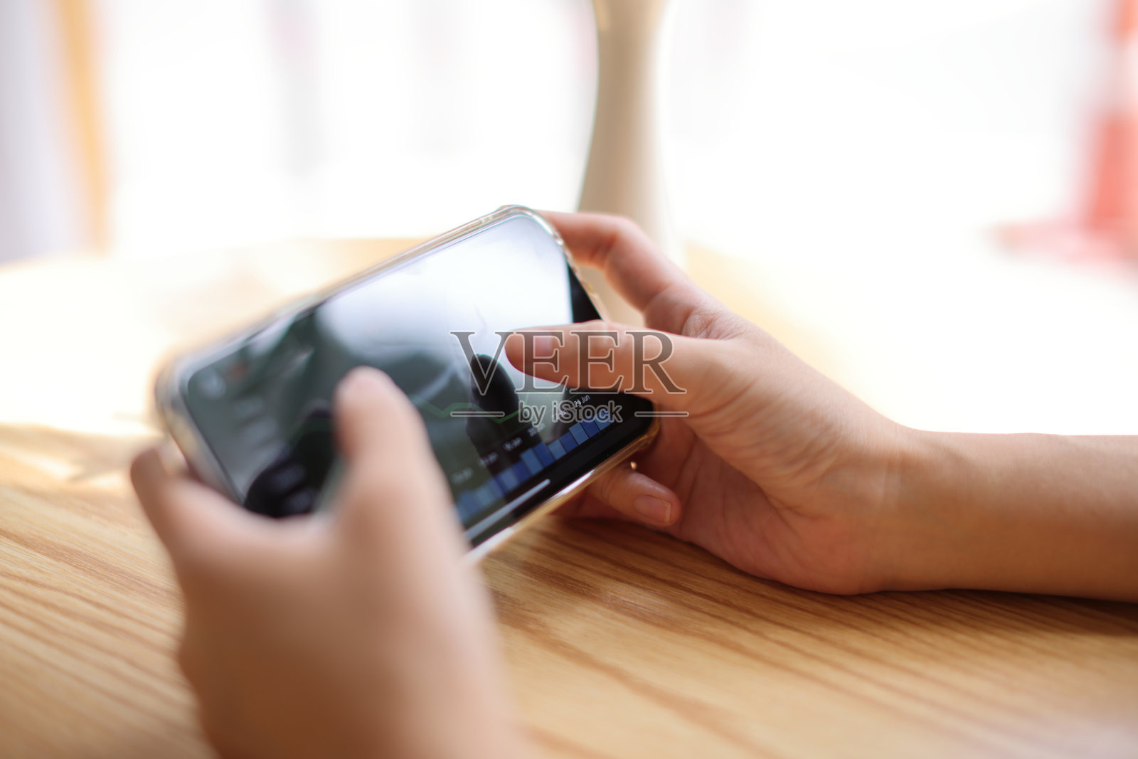 女子手持智能手机，在网上咖啡店进行证券交易，经营理念照片摄影图片