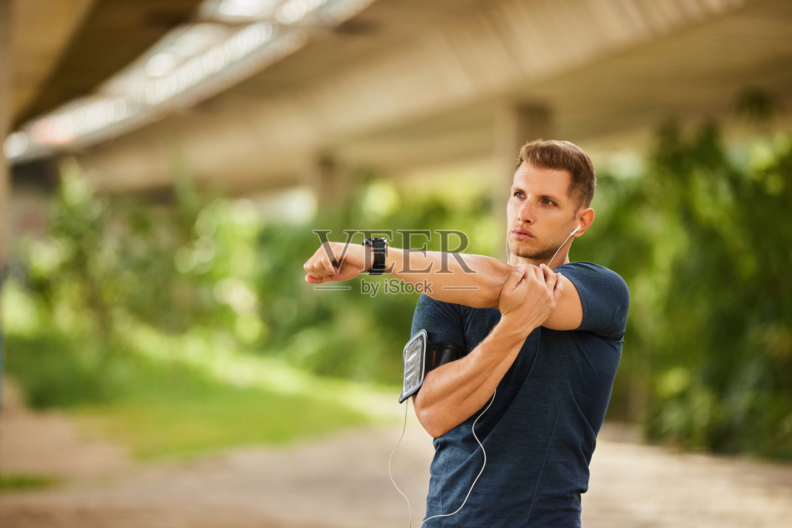 户外锻炼前，年轻人在桥下伸着手照片摄影图片