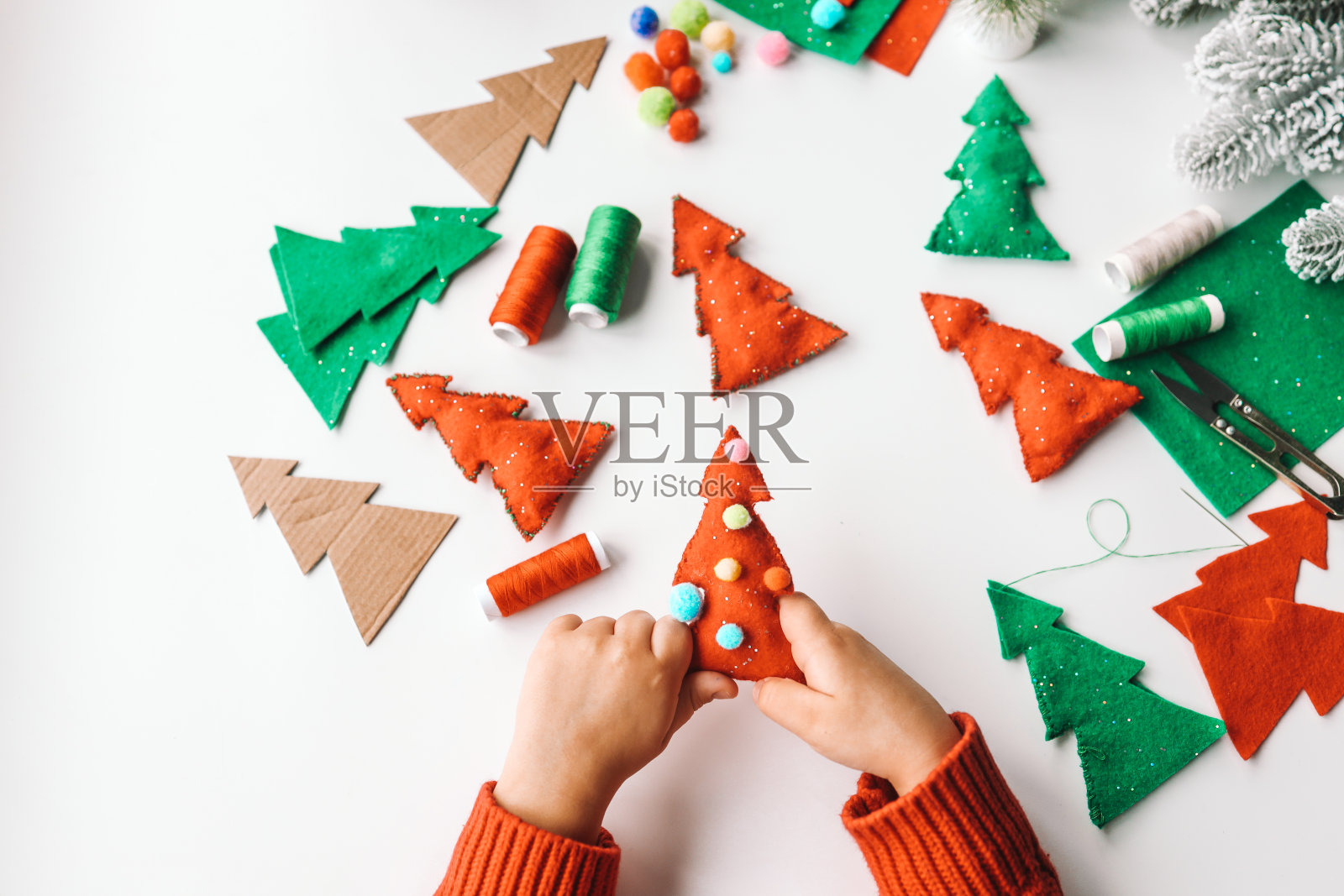 手工缝制软玩具的过程，用毛毡和针装饰圣诞树照片摄影图片