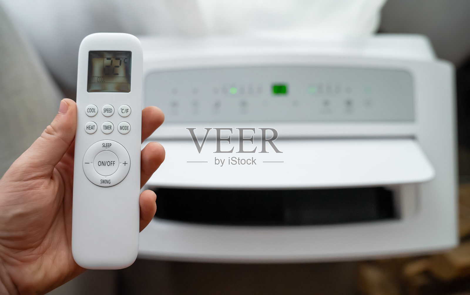 手持遥控器针对落地式移动空调。照片摄影图片