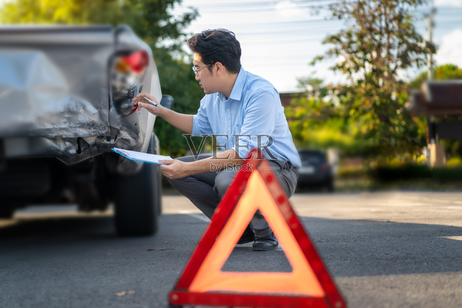 汽车保险代理人在事故发生后检查和评估损坏的汽车，并将其记录为保险索赔的证据。照片摄影图片