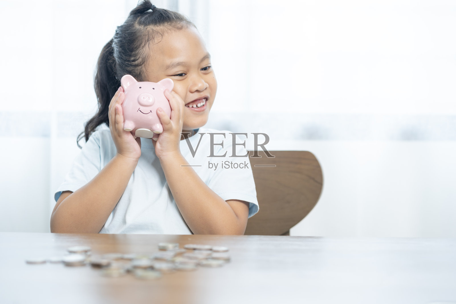 这个小女孩正在为她的教育攒钱。照片摄影图片