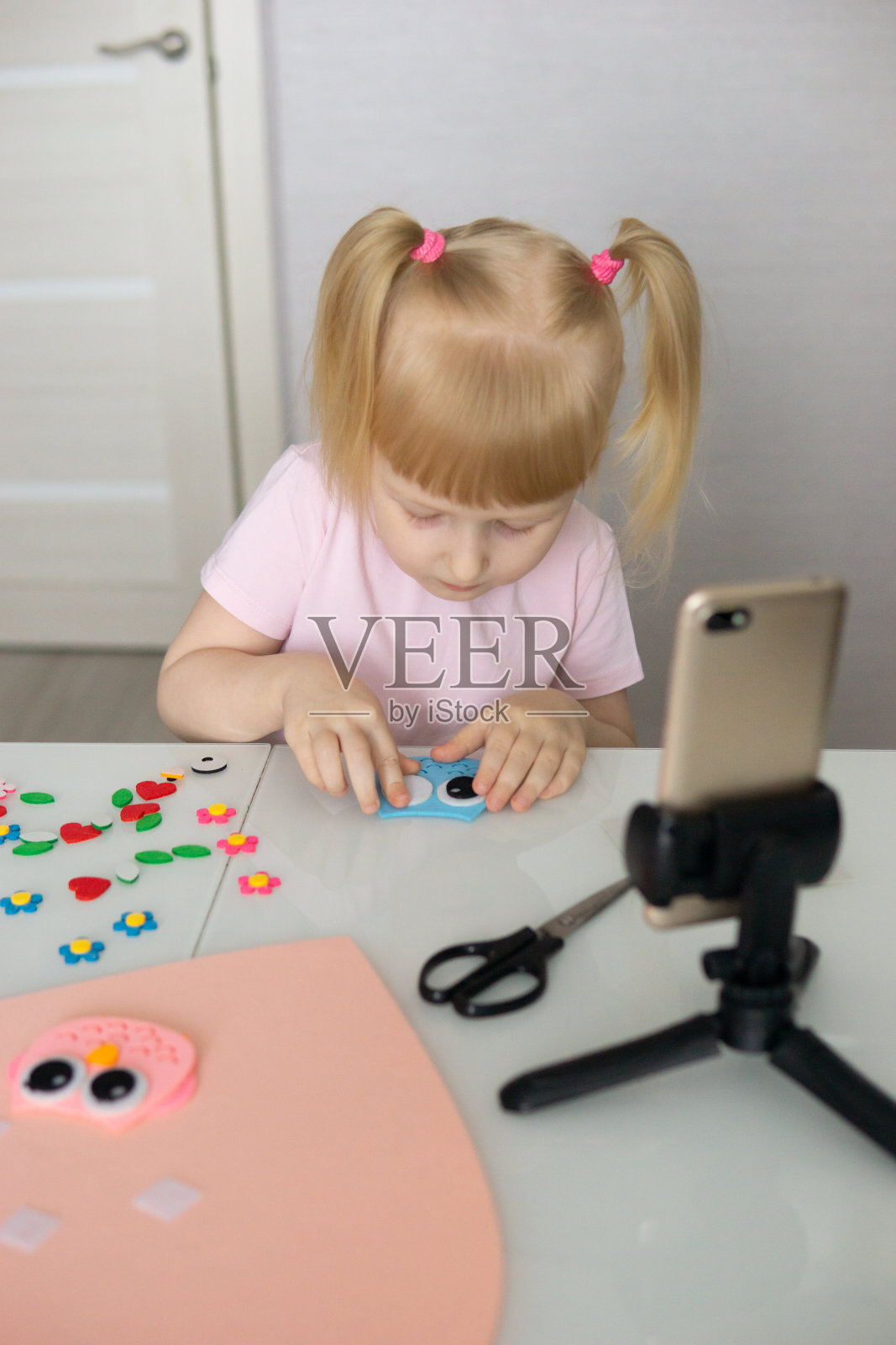 一个博主女孩为情人节做了一个心形的毛毡工艺品。儿童创意与手工的概念。照片摄影图片