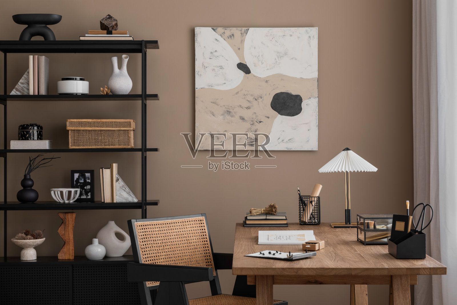 创意组合温馨舒适的办公室内部，模拟海报框架，木桌，藤椅，时尚的灯，黑色的架子，书籍和办公配件。家居装饰。模板。照片摄影图片