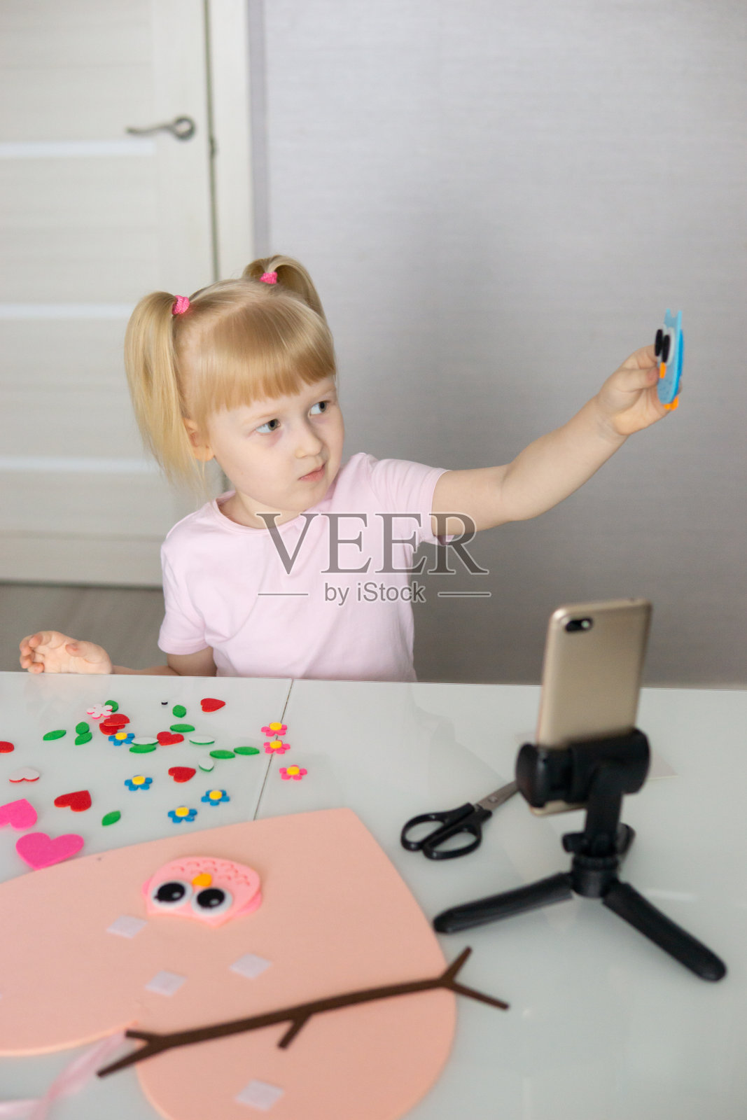 一个博主女孩为情人节做了一个心形的毛毡工艺品。儿童创意与手工的概念。照片摄影图片