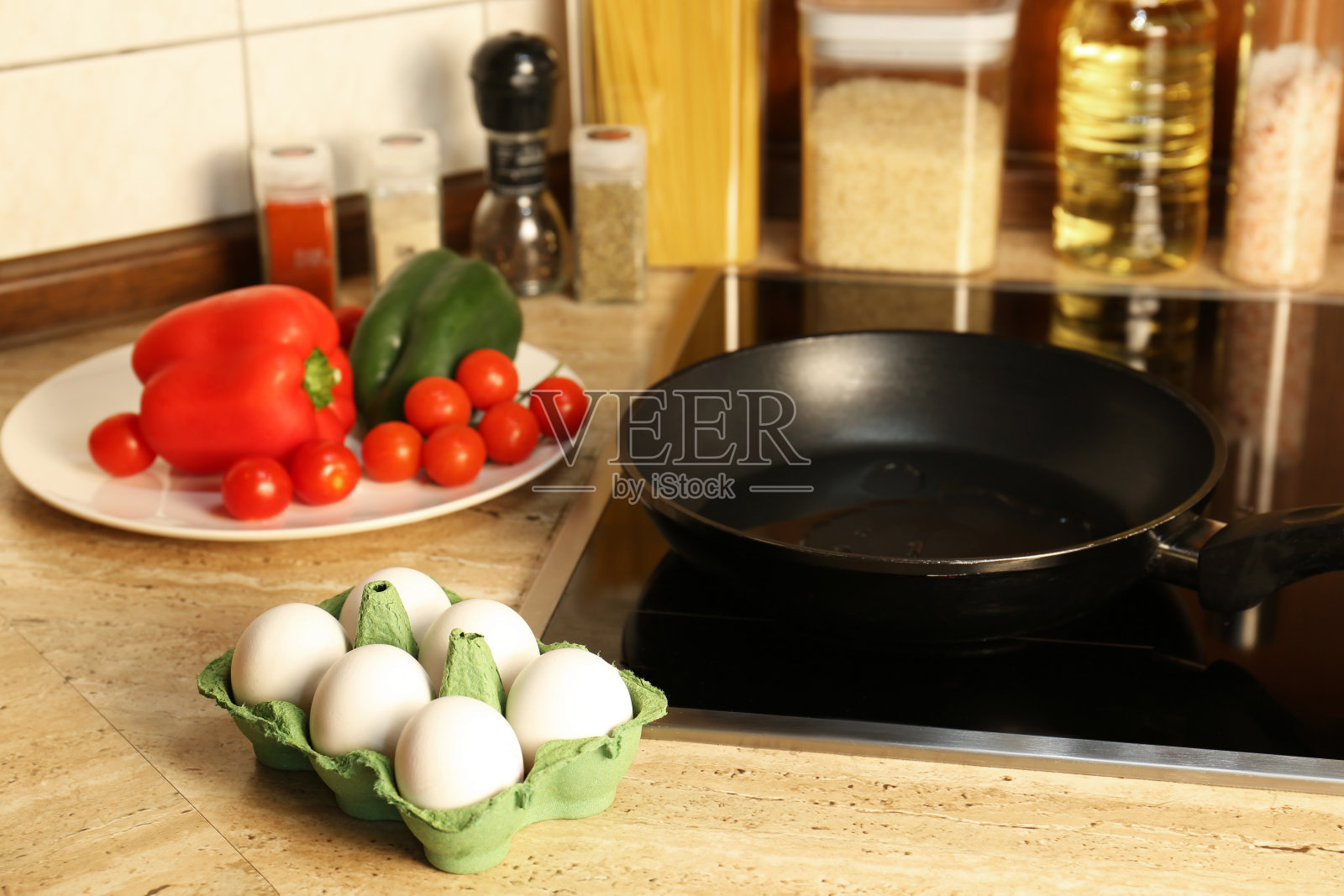 厨房木质台面上的煎锅旁放着许多新鲜的鸡蛋和蔬菜照片摄影图片