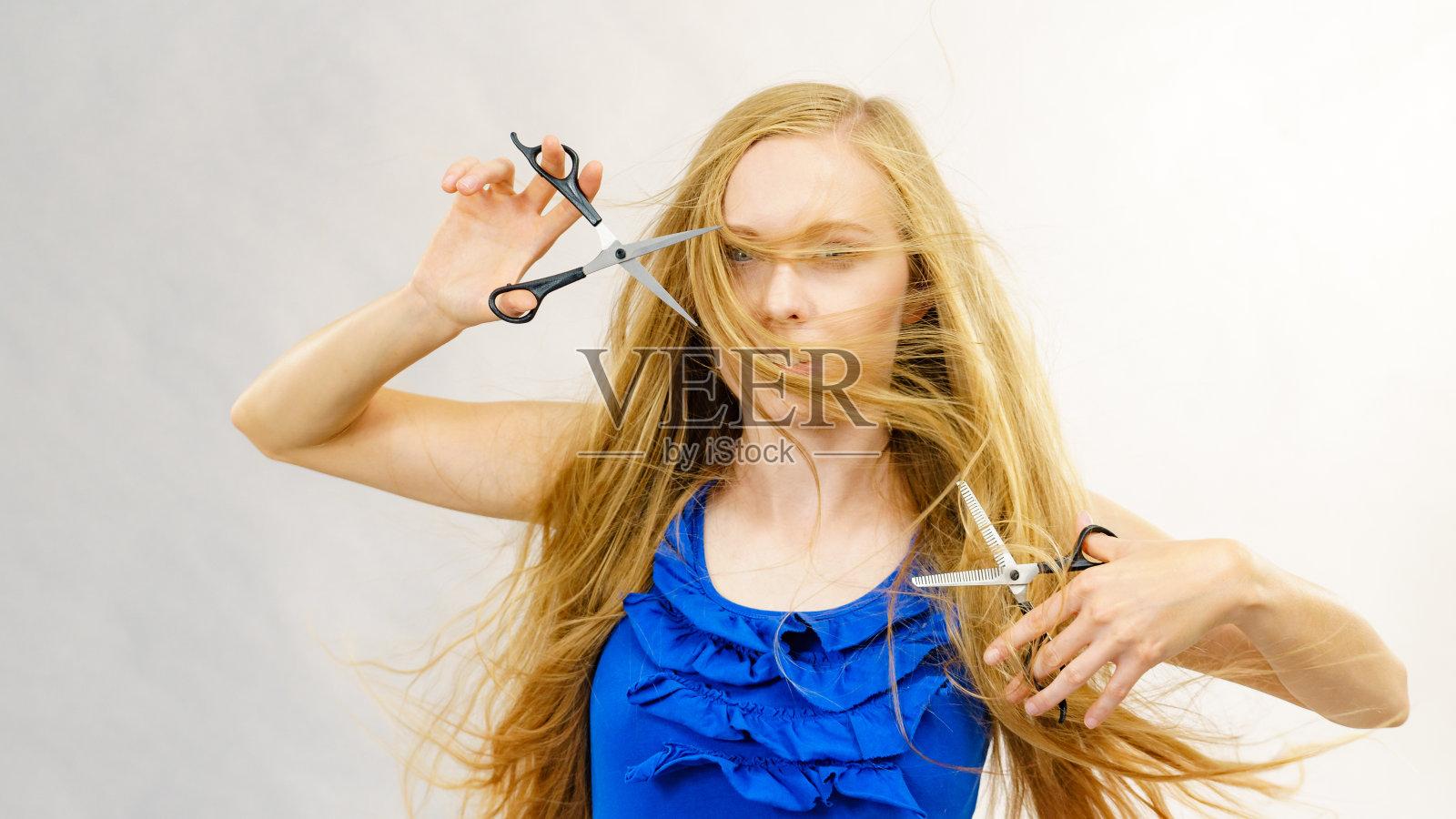 女孩拿着剪刀剪头发照片摄影图片