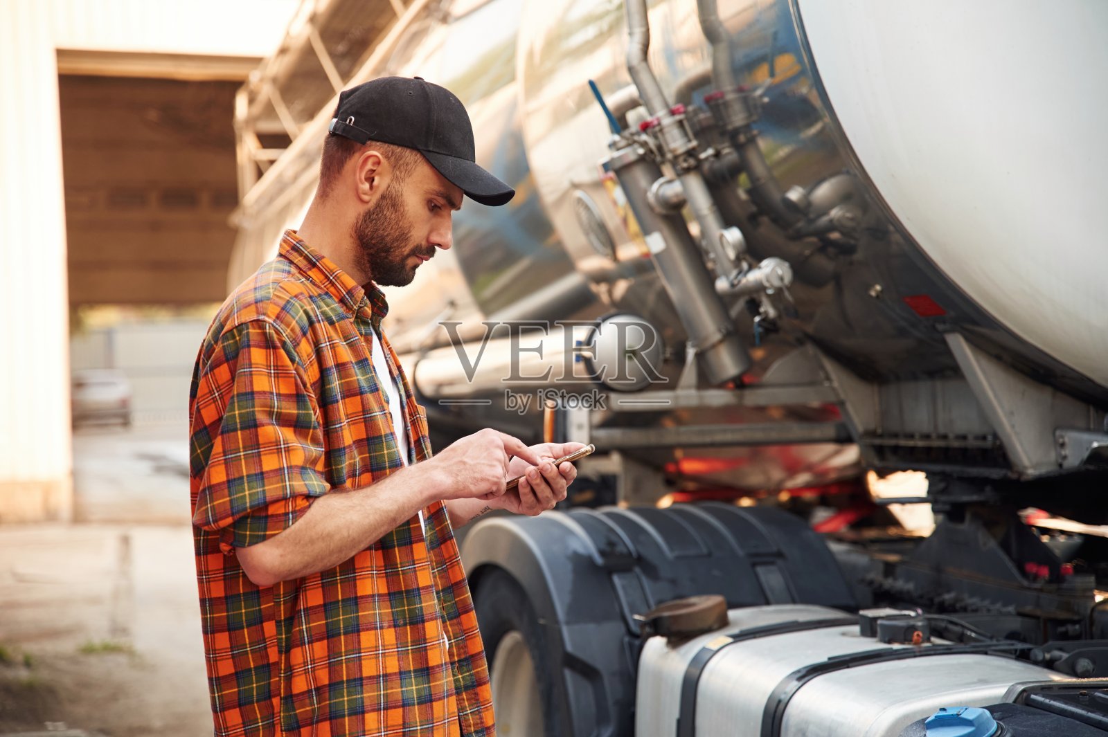 智能手机。穿着便服的年轻卡车司机照片摄影图片