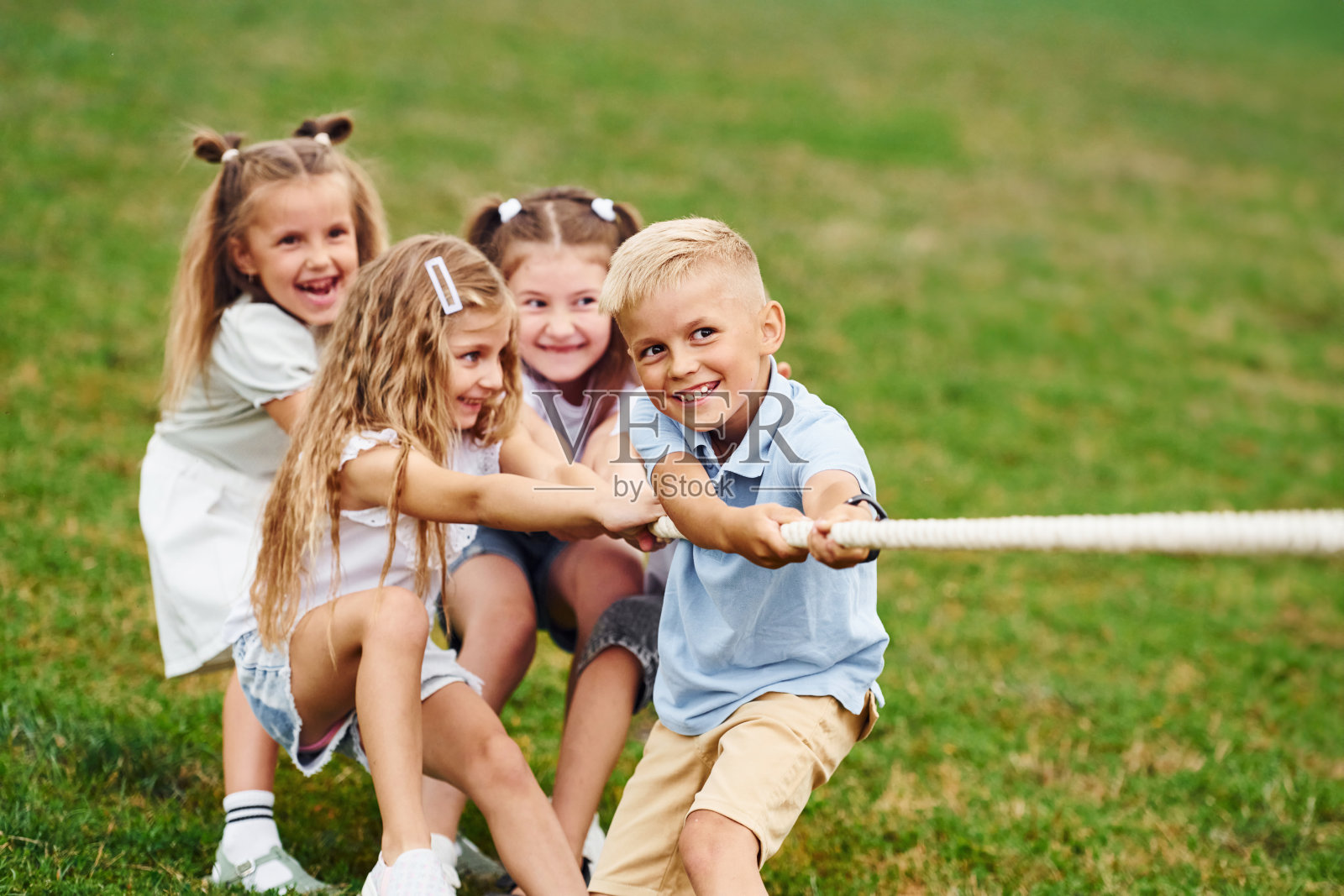 奋斗是真实的。玩拔河游戏。孩子们白天一起在操场上玩得很开心照片摄影图片