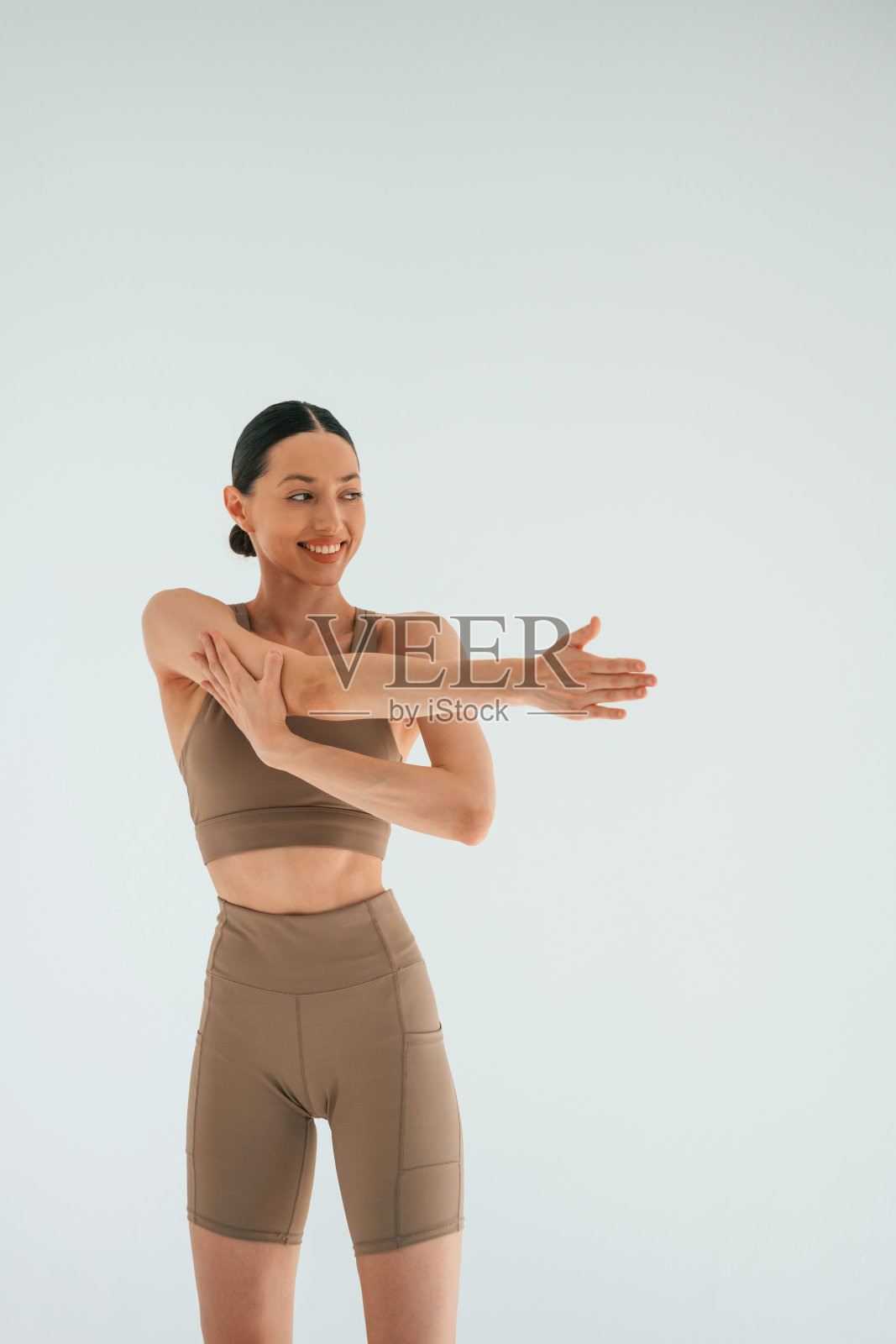 微笑，感觉很好。身材苗条的年轻女子在演播室里穿着健身服照片摄影图片