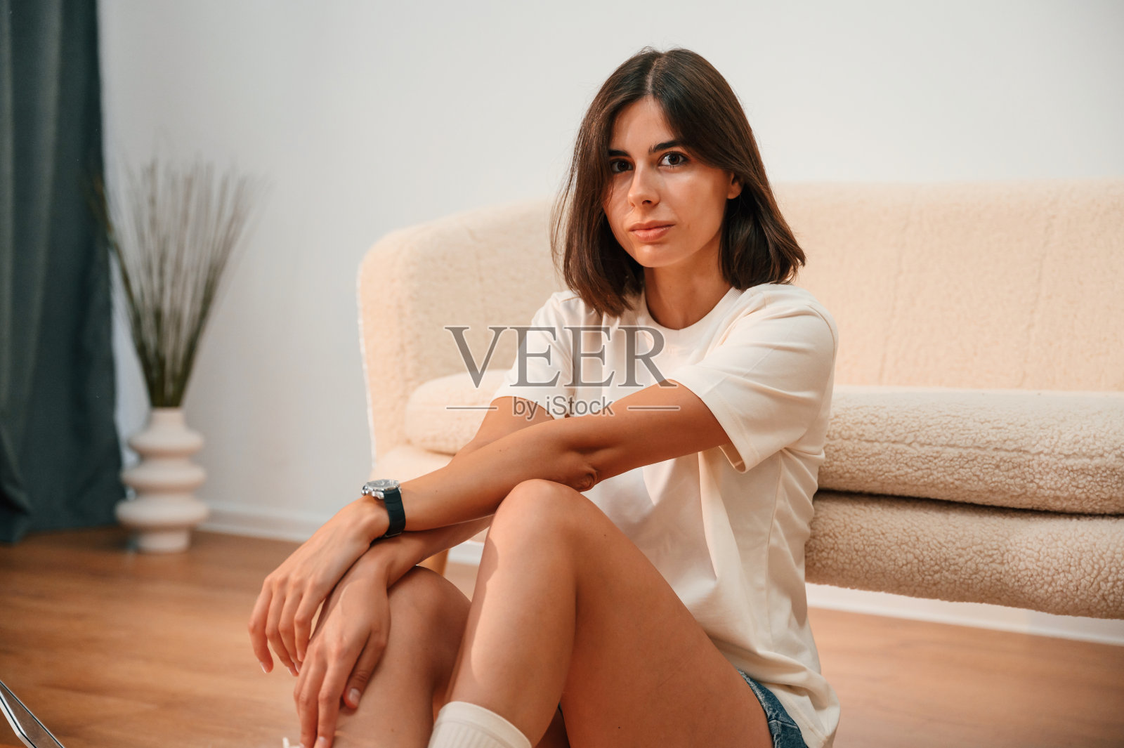 在地板上。穿着便服的美女在家庭房间里是自在的照片摄影图片