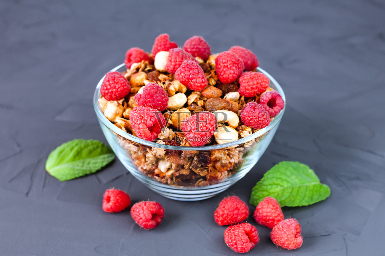 一碗美味的全麦格兰诺拉麦片配上新鲜的覆盆子。健康早餐概念。自制格兰诺拉麦片。失去。照片摄影图片