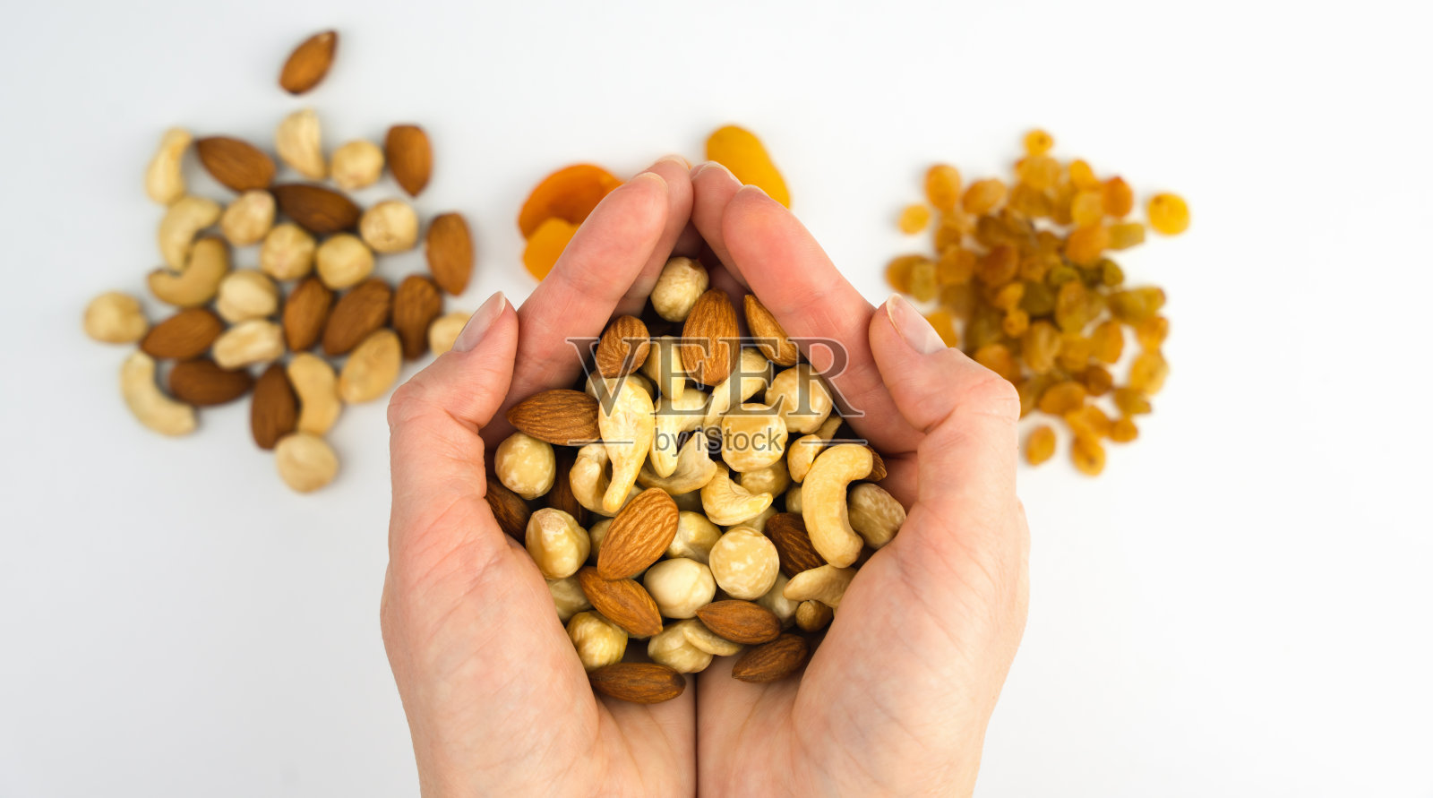 女人的手拿着白色背景上的坚果。健康的早餐。特写镜头。有选择性的重点。前视图。照片摄影图片