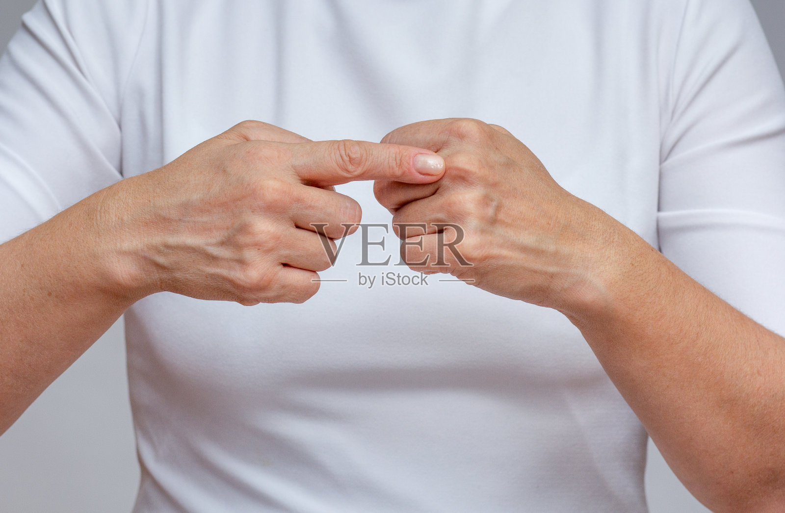 女人用食指指着手上的第二个指节来识别关节炎照片摄影图片