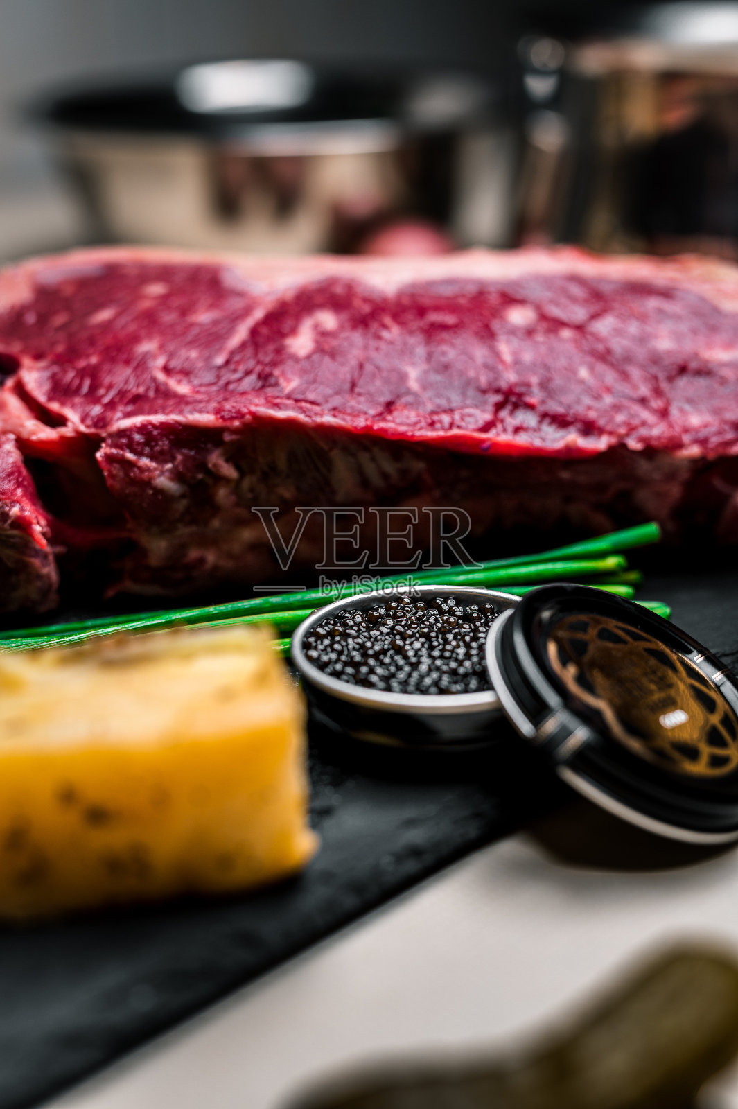 黑板上的生肉块配上土豆和鱼子酱。细节。照片摄影图片