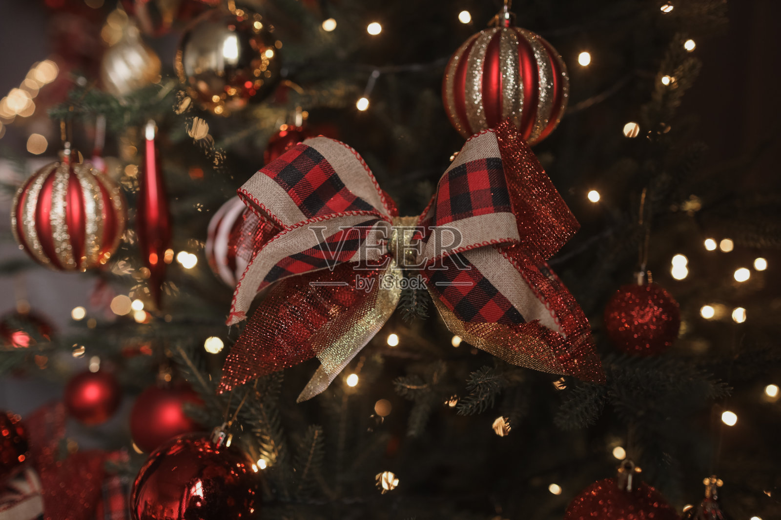 圣诞树上有红色的球和蝴蝶结。新年和圣诞节。照片摄影图片