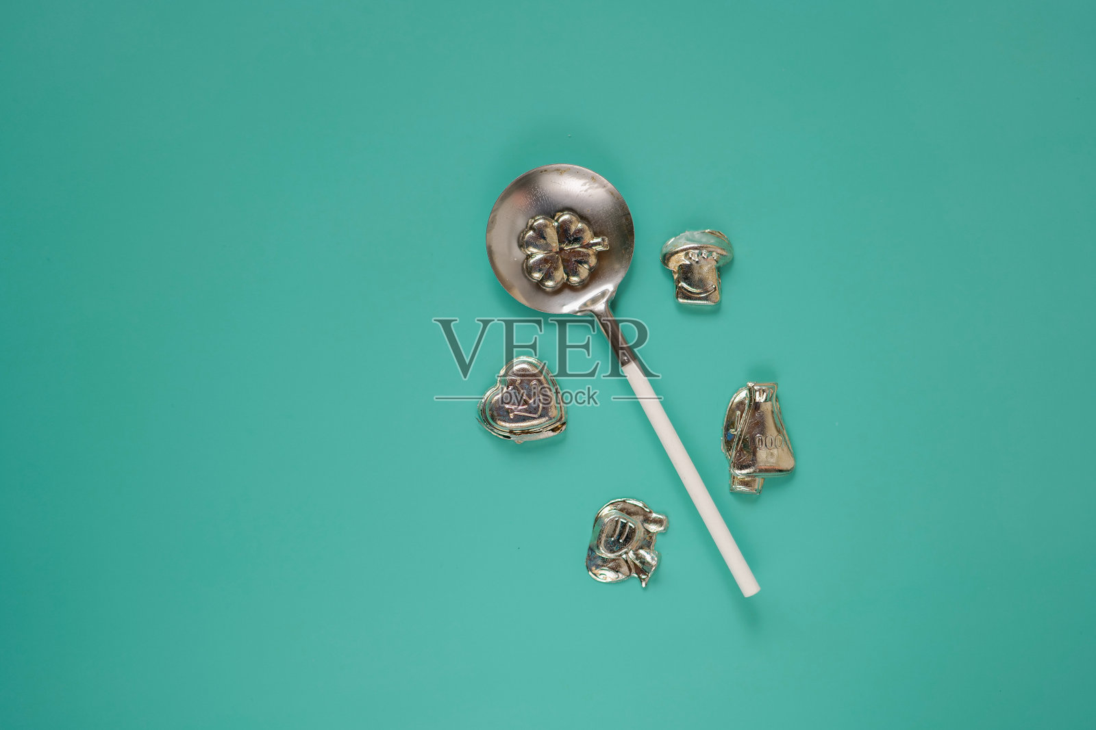 铅浇铸圣诞算命套装。新年派对上有趣的锡铸造套装。蓝绿色背景上的锡勺子和锡小雕像。德国圣诞传统习俗照片摄影图片